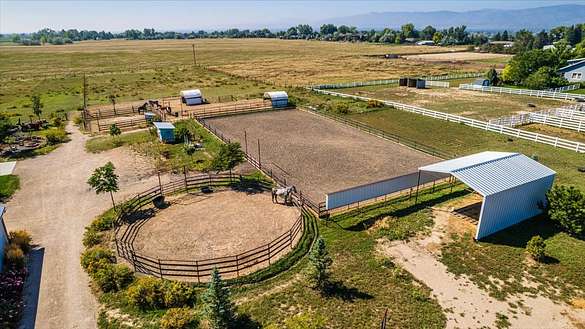 Arial looking south with riding arena, mirrors, round pen, hay storage, back pastures.